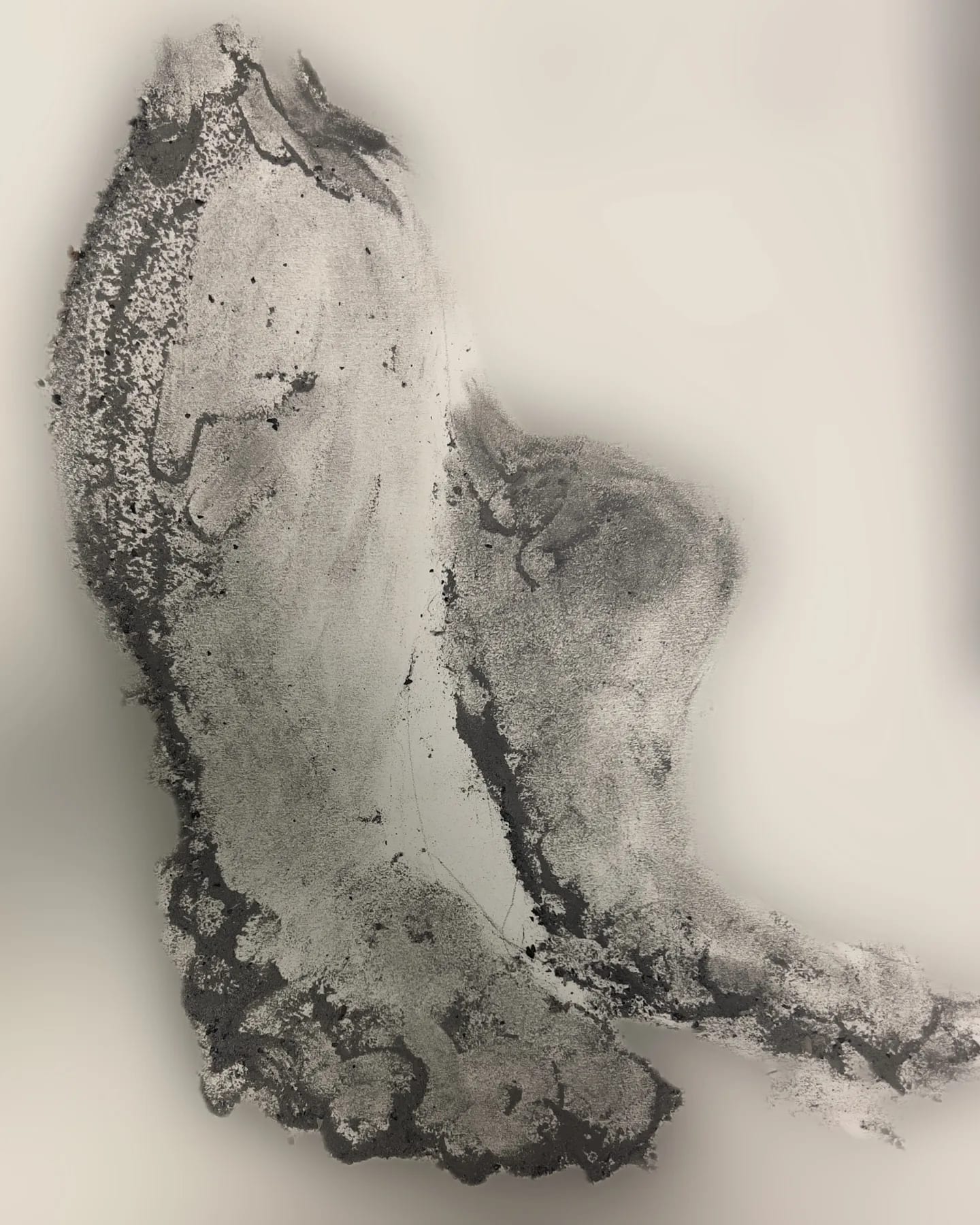 A grey body-shaped transfer made from cigar ash on a pale surface.
