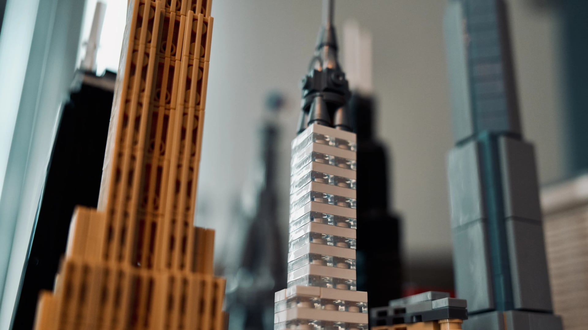 LEGO skyscrapers in gold, white, black and translucent blue seen at close range.