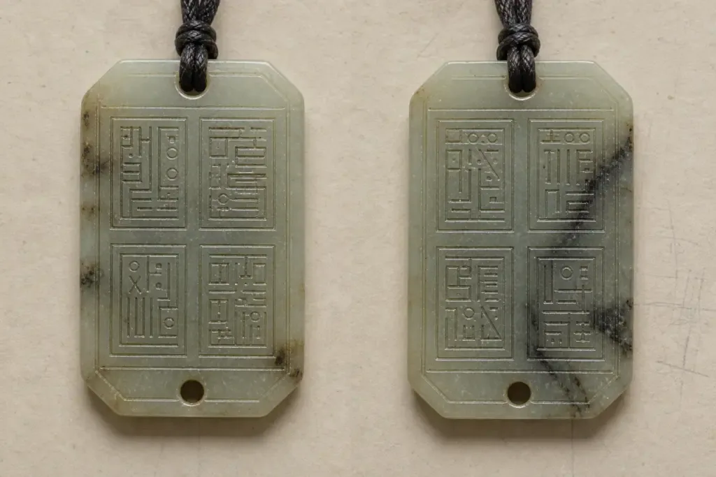 Generated visual study of a pale green pendant shown front and reverse, with four recessed inscription fields on each side.
