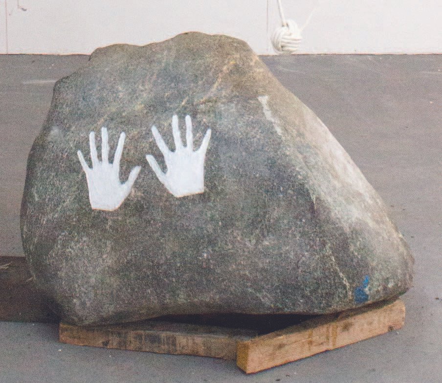 Boulder with two engraved white handprints, marking the artist’s repeated action of pushing the stone as part of a durational performance.