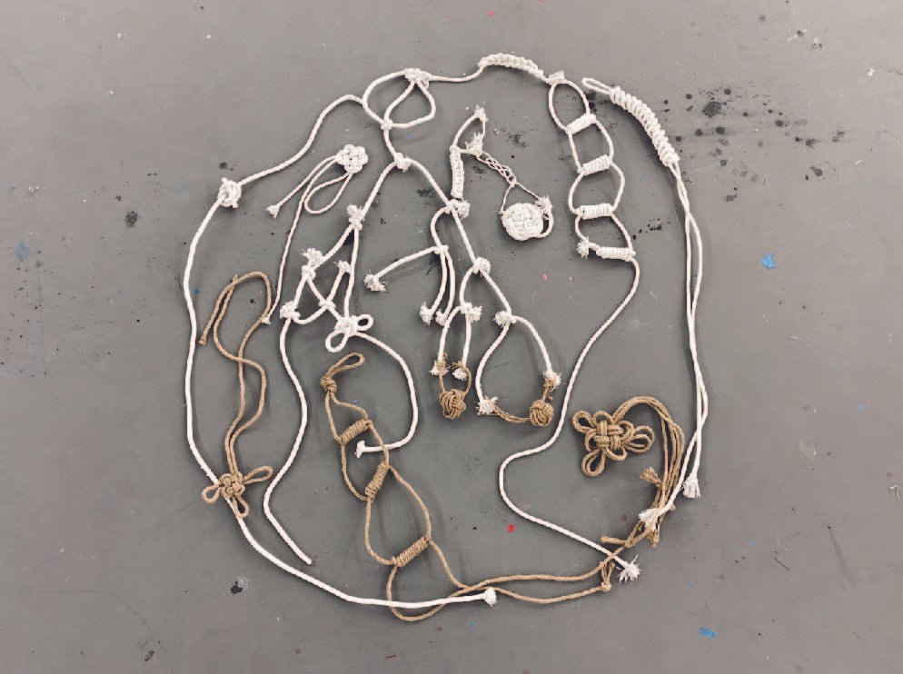 Circular composition of cotton and jute knots linked into a closed loop.